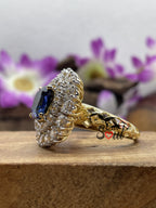 Cushion cut blue sapphire halo engagement ring with moissanite cluster in 14K yellow gold