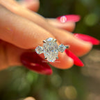 Oval cut moissanite three stone engagement ring in 14K white gold with VVS colorless center stone