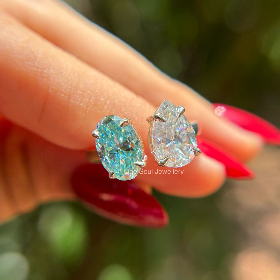 Toi et moi engagement ring with cyan blue oval moissanite and colorless pear moissanite in 14K white gold