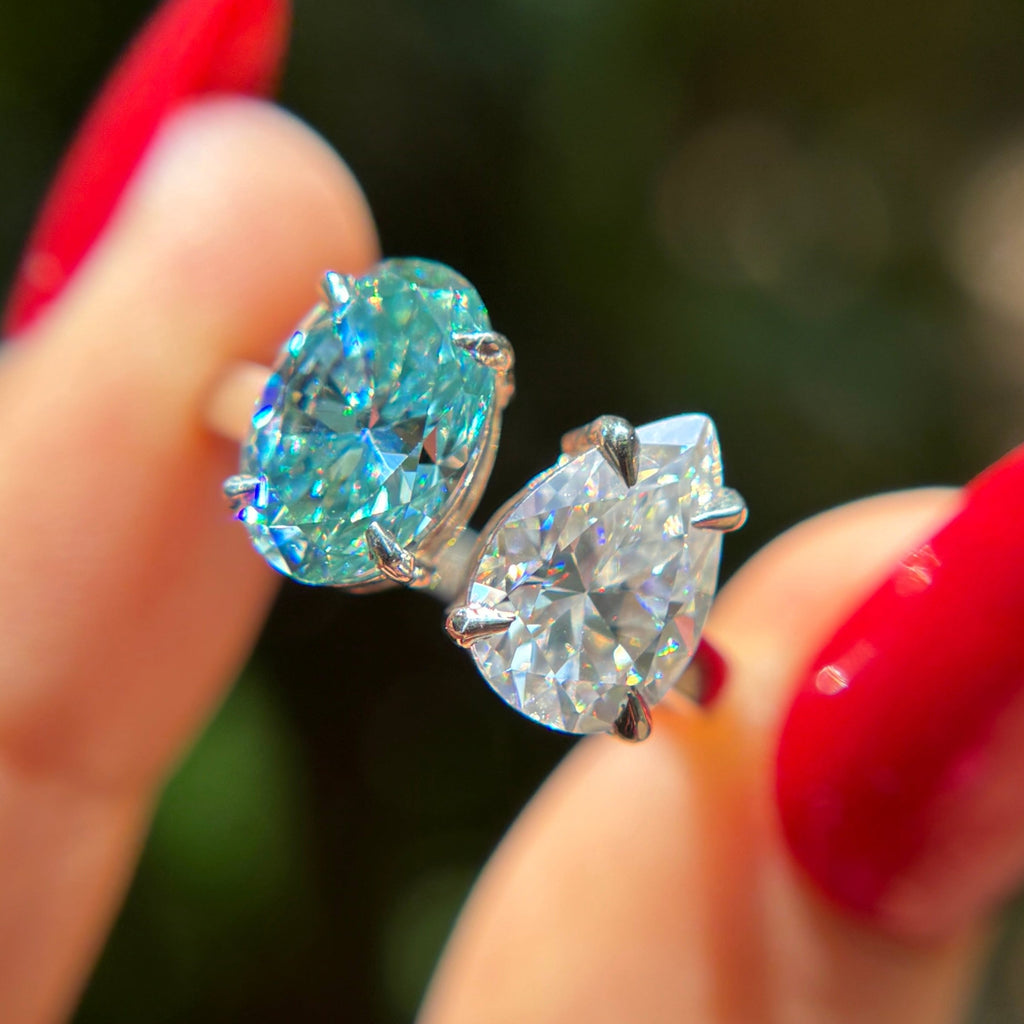 Toi et moi engagement ring with cyan blue oval moissanite and colorless pear moissanite in 14K white gold