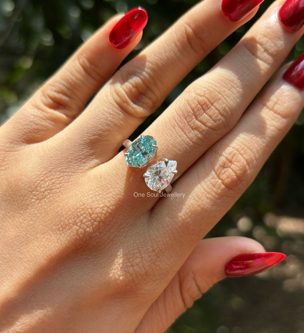 Toi et moi engagement ring with cyan blue oval moissanite and colorless pear moissanite in 14K white gold