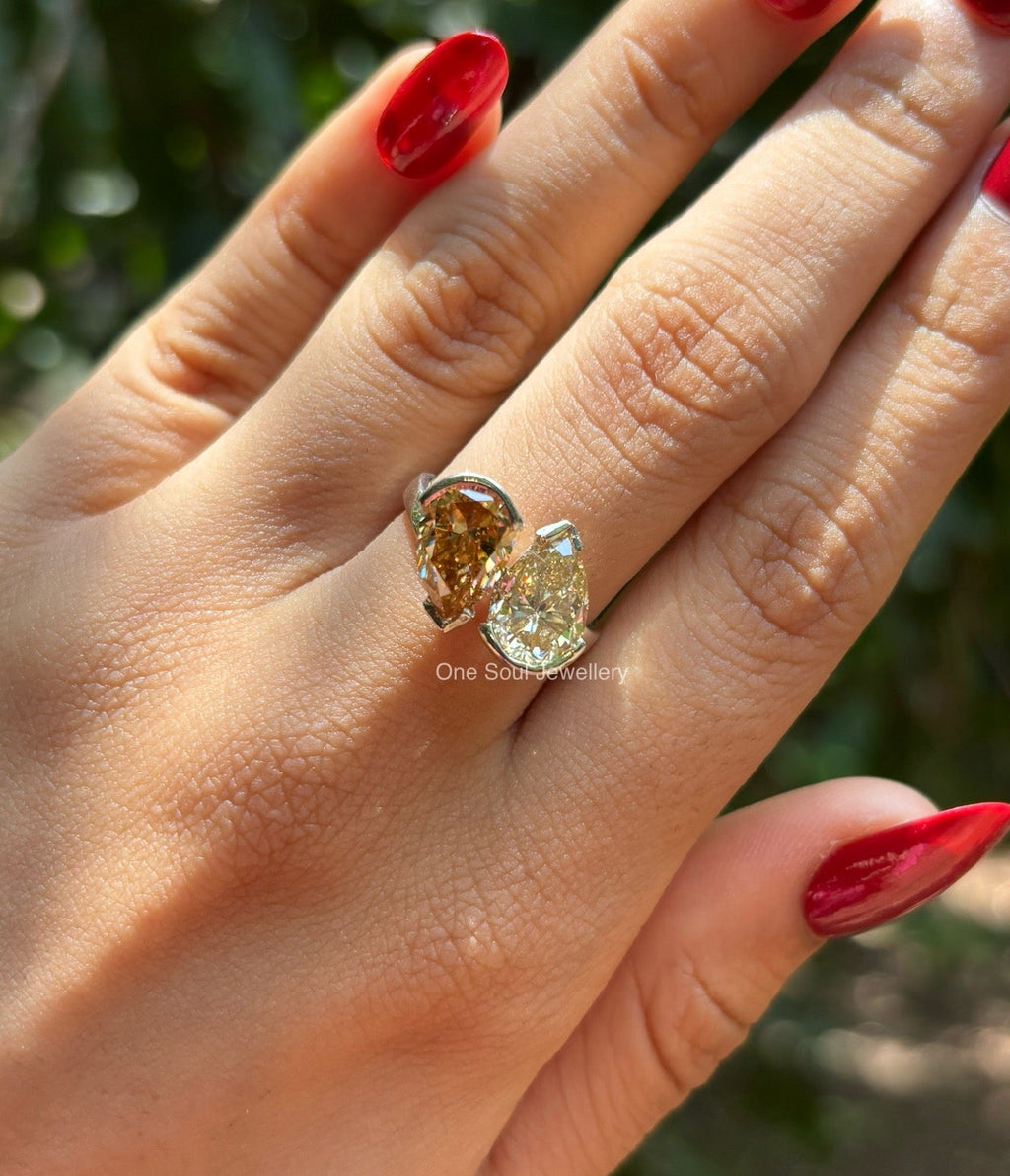 Toi et moi engagement ring with cyan blue oval moissanite and colorless pear moissanite in 14K white gold